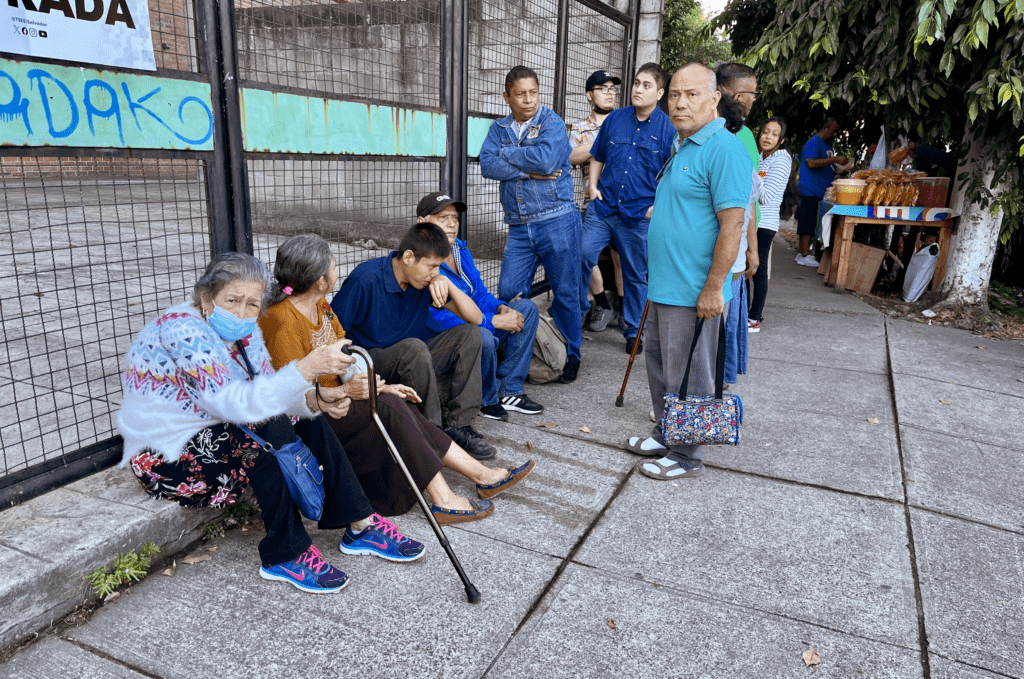 Fila de votantes a la espera de ingresar al centro de votación.